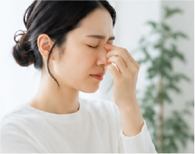 女性が鼻のあたりを押さえている画像